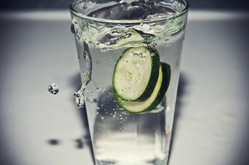 cucumber slices in a glass of water splash