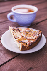 Delicious and sweet pie on a saucer with a cup of tea