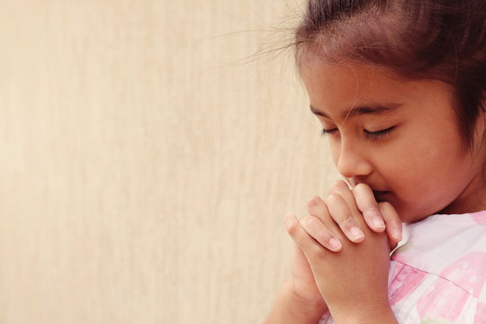 multicultural hispanic girl child praying with eyes closed, christianity faith concept