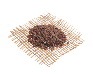 Brown Flax Seed. Grains over hessian fabric, isolated white background.