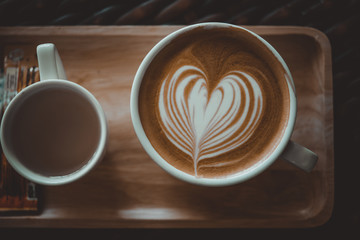 Close up latte art on wooden plate in coffee shop vintage style,selective focus