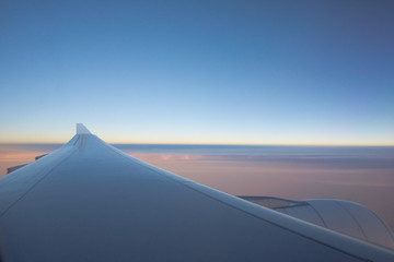 Fototapeta na wymiar Aeroplane Wing At 30,0000 Feet Above Ground During Sunset