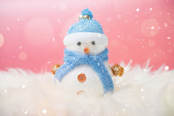 Happy snowman standing in blue winter christmas snow background. Merry christmas and happy new year greeting card with copy-space.