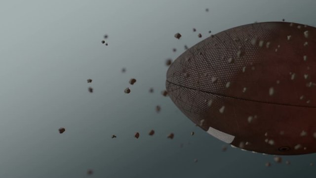 A dirty american football ball caught spinning in slow motion flying through the air scattering dirt particles in its wake - 3D render