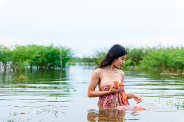 Thailand woman wearing sarong swim in the river.
