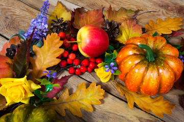 Thanksgiving rustic background with rose, leaves, pumpkin, apple, lilac flowers