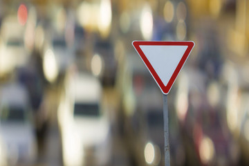 Road sign give way on the background of cars