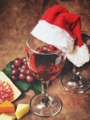 Red wine with cheese sausages and christmas hat
