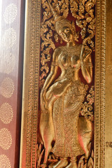 Art Craft of Devas on the door in Wat Xiengthong, Luang Prabang, Laos.