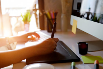 Young hipster graphic designer woman using digital graphic tablet while working at modern office.