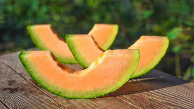 Slices of melon on a wooden background