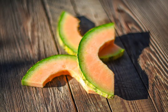 Slices of melon on a wooden background