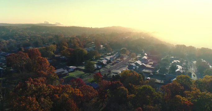 A slow forward aerial establishing shot of a typical Western Pennsylvania residential neighborhood on a foggy late-Autumn morning. Pittsburgh suburbs. Shot at 60fps.  	