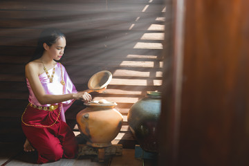 Portrait of Thai woman in thai dress in ancient wooden home