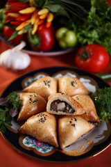 Samsa are triangular in shape with a lamb and a big piece of sheep fat.The puff pastry on top sprinkled with Nigella.Bake in the tandoor.Uzbek cuisine.The upper projection