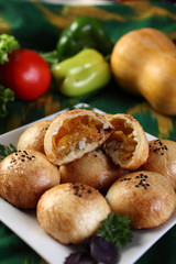 Samsa with pumpkin.Surface grease soaked seeds of black cumin and bake in the tandoor.Uzbek cuisine.The upper projection.