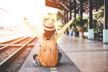 Tourist asian lifestyle women wearing backpack holding map, traveler siting for waiting a train, so happy and relax for summer day, Travel Concept..