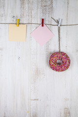 Pink donut and and two sheets of paper