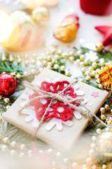 Christmas and New Year background with thuja branch, decorations and presents wrapped in craft paper with snowflakes.