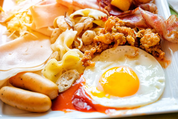 Morning breakfast with fried egg, sausages and bacon
