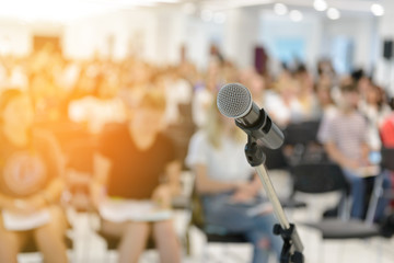 Microphone over abstract blurred of attendee in seminar room