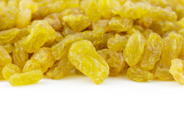 row of golden raisins isolated on white background