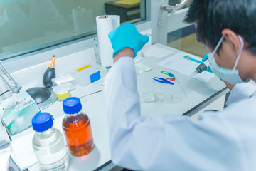 The scientists injected chemicals into plastic tubes,Suientist working in the lap,open low light for test sample