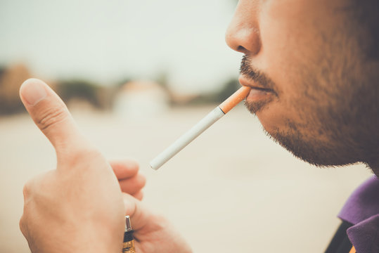 Asian man use lighter cigarette to smoke,no world tobacco day