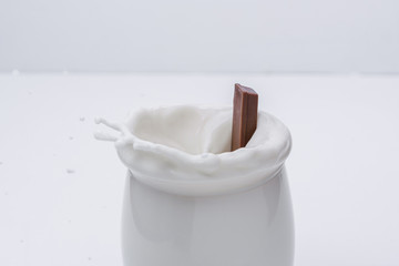 Splas de chocolate en vaso de leche con fondo blanco