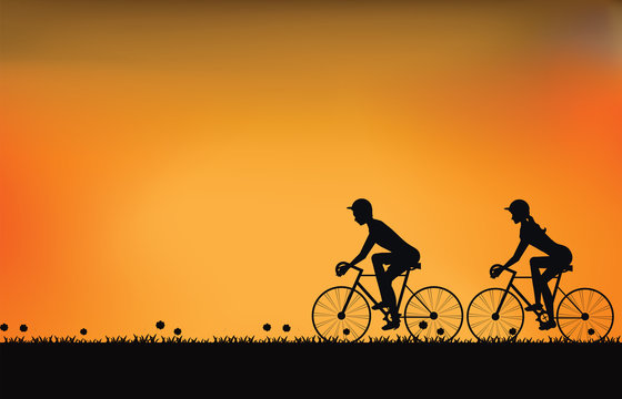 Silhouette of couple driving bike with beautiful sky at sunset.