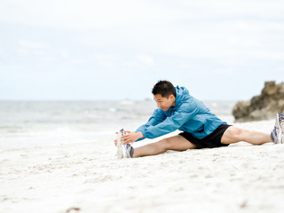Fototapeta na wymiar Young man doing exercise at the beach