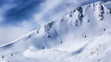 ski gondola lift with snowcapped mountain background