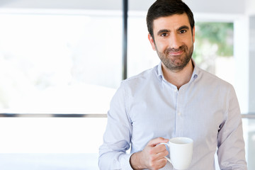 Young businessman in office with a mug