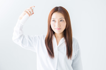 ヘアスプレーする女性
