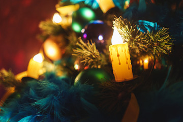 Branches of a Christmas tree with beautiful decorations on a blurred background.