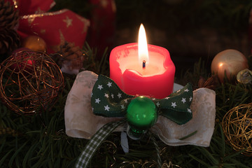 stimmungsvolle weihnachtliche Deko - rote Kerze mit schöner Schleife, Kerzenlicht