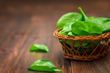 Fresh juicy spinach leaves on a wooden brown table. Natural products, greens, healthy food, vitamins.