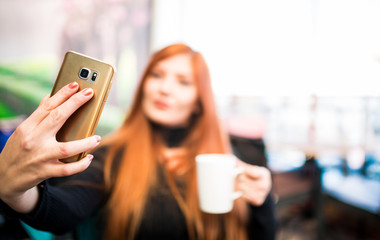 Obraz na płótnie Canvas Beautiful girl drinking coffee at the coffee shop