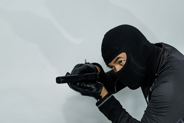 Criminal with gun in hand on white background,low key style,dark tone,selective focus