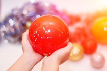 Christmas decorations. Cristmas balls in a hand. The effect of shine and glow. Merry Christmas