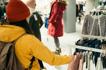 Woman shopping clothes. looking for new clothes in store