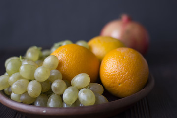 oranges and grapes on wooden background