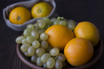 oranges and grapes on wooden background