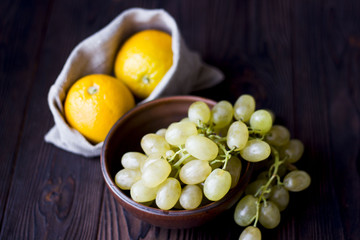 oranges and grapes on wooden background