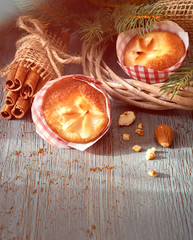 Lemon muffins on rustic wooden table with Christmas twigs, almonds and cinnamon sticks