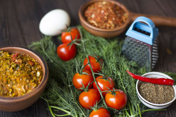 tomatoes, dill, chili and spices on a wooden table