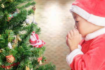 Merry Christmas.Cute little child is decorating the Christmas tree.