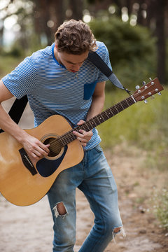 Talented guitarist playing forest hiking concept. Lifestyle of the artist. Unity with the nature.
