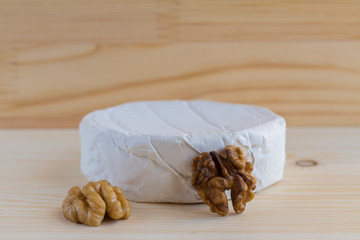 camembert and walnut on wooden background