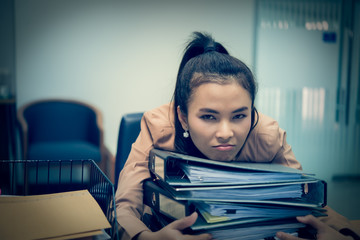 Asian woman working in office,young business woman stressed from work overload with a lot file on the desk